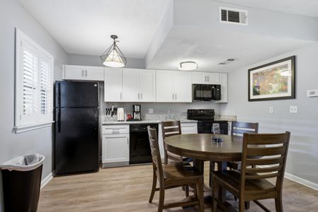 Unit 306 – Sleek kitchen w/ bold cabinetry & dining area for gathering together.