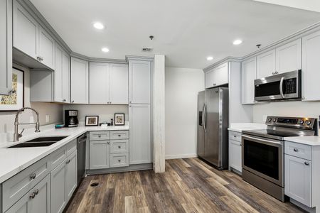 Full kitchen w/ light cabinets, stainless fridge & tile backsplash.