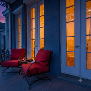 Unwind on the balcony w/ red accent chairs & gorgeous views right outside the door.