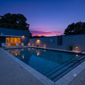 Lounge poolside w/ plenty of seating & bright, open skies overhead.
