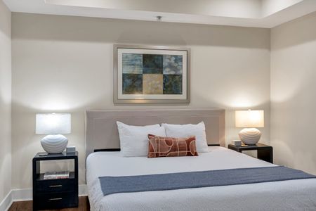 Framed geometric art above a plush bed