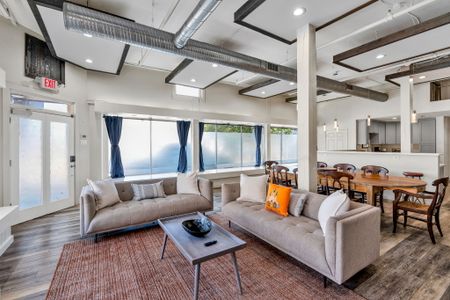 Sunlit lounge with soaring windows and exposed beams