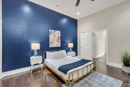Brass bed and modern art against deep navy