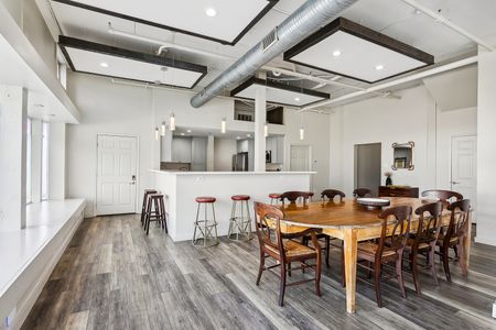 Open living & dining area w/ bar-style seating & exposed-beam ceiling.