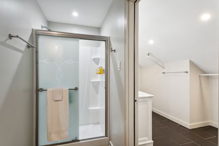 Glass-door shower w/ handy shelving.