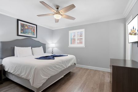 Airy bedroom bathed in soft light, w/ a smart TV for winding down.