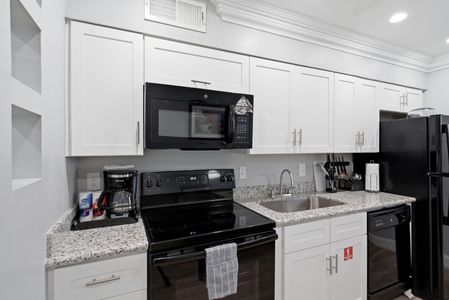 Well-equipped kitchen w/ full appliances & a sink ready for home cooking.