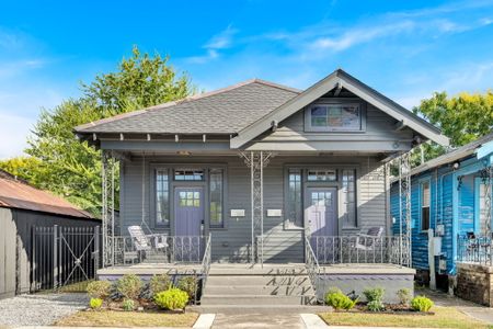 Charming craftsman-style home w/ a covered front porch & leafy landscaping