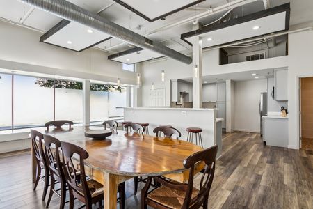 Airy dining area w/ wood table, seating for a crowd & natural light.
