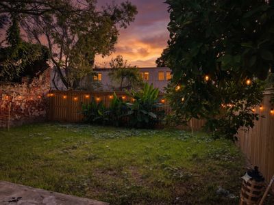 Spacious backyard w/ lush green lawn — plenty of room to relax or play outside.