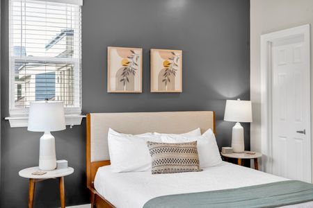 Botanical prints above a plush upholstered bed