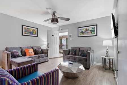 Welcoming living room w/ ceiling fan & a clear sightline to the entryway.