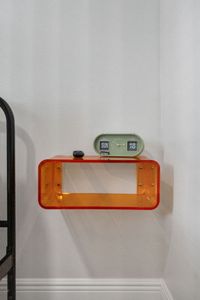 Playful orange floating shelf & retro flip clock add a pop of personality