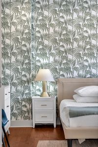 Palm-print accent wall and a soft lamp glow