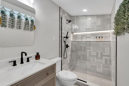 Refresh under the rainfall shower in this sleek bathroom w/ modern black fixtures & stylish tile
