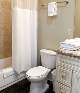 Clean bathroom with shower area and neatly arranged fresh towels