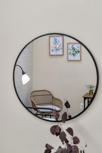Round mirror reflecting a cozy reading spot