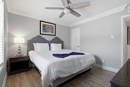 Calm & comfortable bedroom w/ a bed dressed in crisp white linens.
