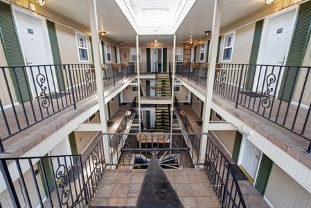 Classic New Orleans-style gallery walkway w/ iron railings wrapping around the building.