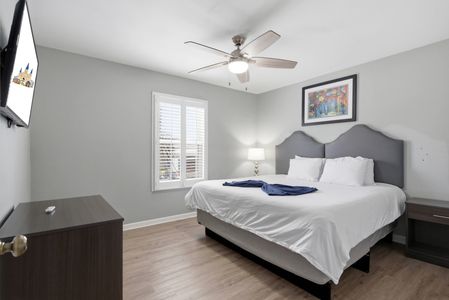 Airy bedroom w/ a ceiling fan, natural light & a cozy bed to recharge.