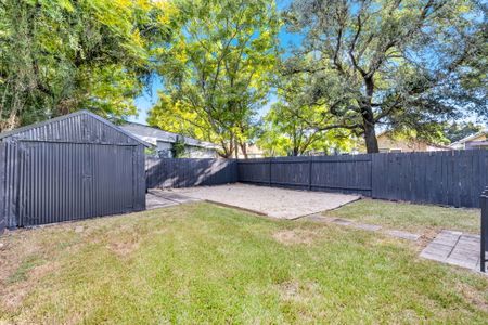 Let the kids or pup roam in the fenced backyard w/ lush green grass under leafy shade trees
