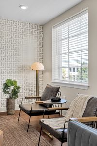 Reading chair tucked beside textured wallpaper