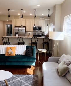 Living area w/ teal velvet sofas & warm hardwood floors for easy lounging