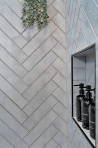 Modern herringbone tile & sleek black accents give the bathroom a spa-like feel