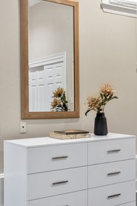Warm wood mirror over a bright white dresser