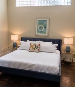 Airy bedroom w/ crisp white bedding & soft bedside lighting