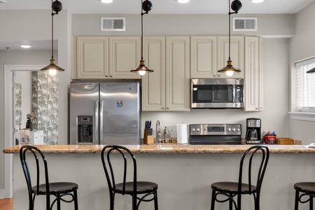 Kitchen bar with bistro chairs and stainless appliances