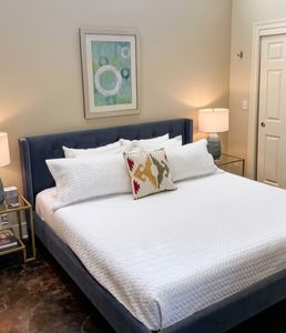 Comfortable bedroom with crisp white bedding and blue accent wall