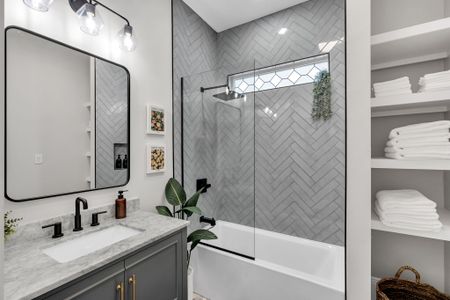 Refresh under the rainfall shower in this bright bathroom w/ herringbone tile & black fixtures