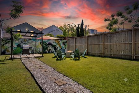 Spacious yard w/ green grass, Adirondack chairs, firepit & a vibrant mural backdrop.