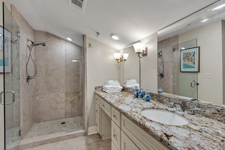 Granite vanity lit by elegant sconces