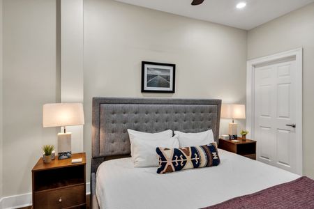 Gray tufted bed with curated gallery art