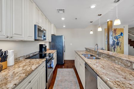 Galley kitchen stocked with stainless appliances