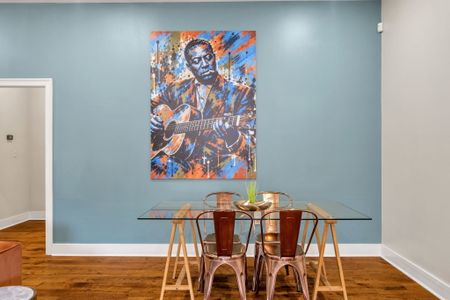 Glass dining table under vibrant portrait art