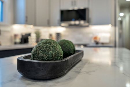 Mossy accents on the kitchen island add a fresh, natural touch
