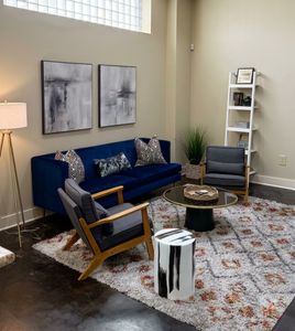 Bright open living space w/ blue sofa & cozy seating area