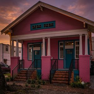 Eye-catching pink Creole cottage exterior — hard to miss & impossible not to love.