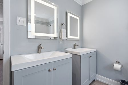 Unit 201 bathroom w/ sleek vanity, lit mirror & a fresh modern finish.