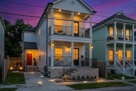 Modern two-story home w/ welcoming balconies & elegant curb appeal.