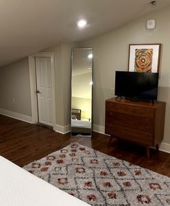 Bedroom with TV and hardwood floors