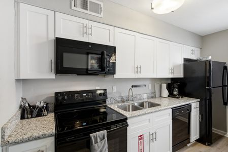 Fully equipped kitchen w/ black appliances & ample cabinet space for easy meal prep.