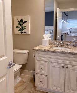 Bathroom w/ granite counters, double sinks & ample storage