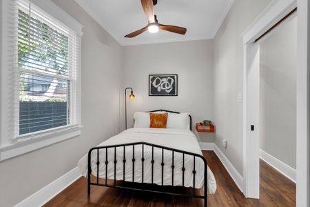 Charming bedroom w/ a classic iron bed, bold wall art & a reading light for winding down