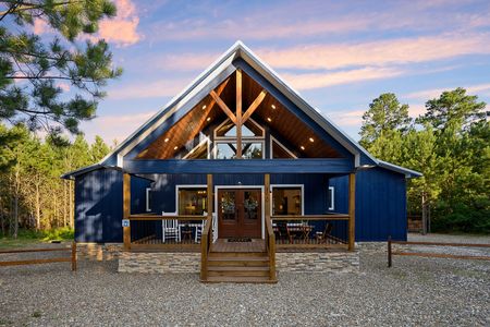 Luxury Bluebird Sky cabin exterior featuring a spacious deck with outdoor dining and a prominent