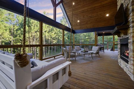 Outdoor living space at Bluebird Sky cabin featuring a porch swing bed, fireplace, and comfortable