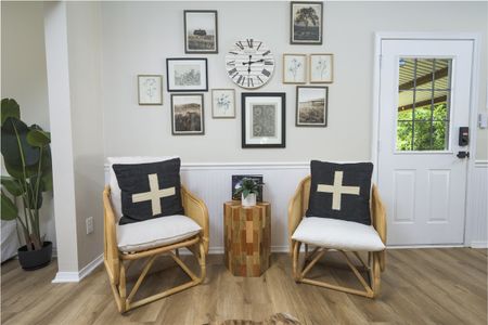 Cozy cabin interior showcasing comfortable armchairs with decorative pillows and a gallery wall of framed